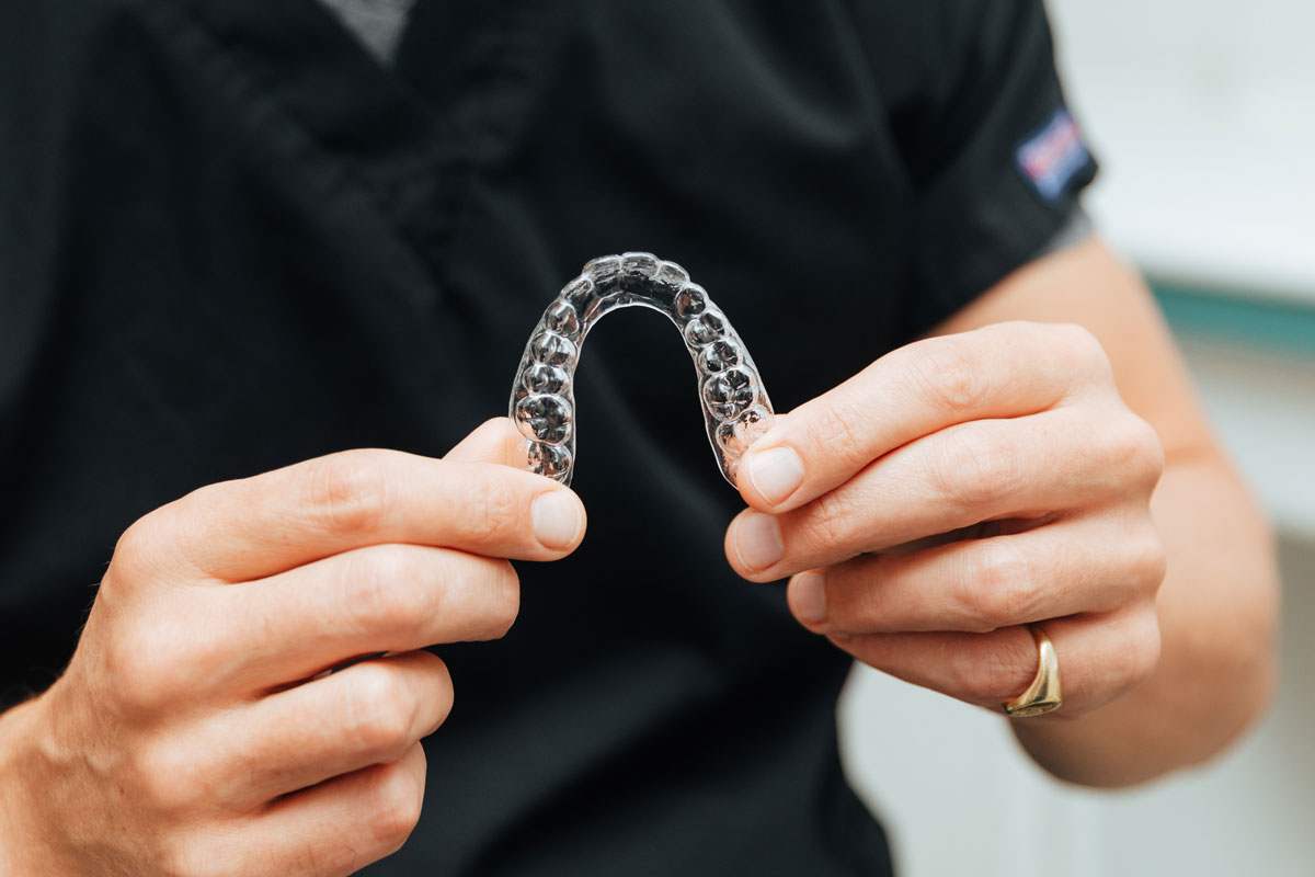 Dentist holding a clear aligner